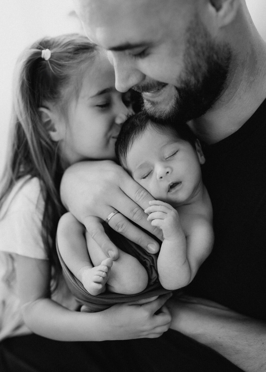 Babyfotografie Wittenberg, Papa und große Schwester kuscheln mit Baby Bruder