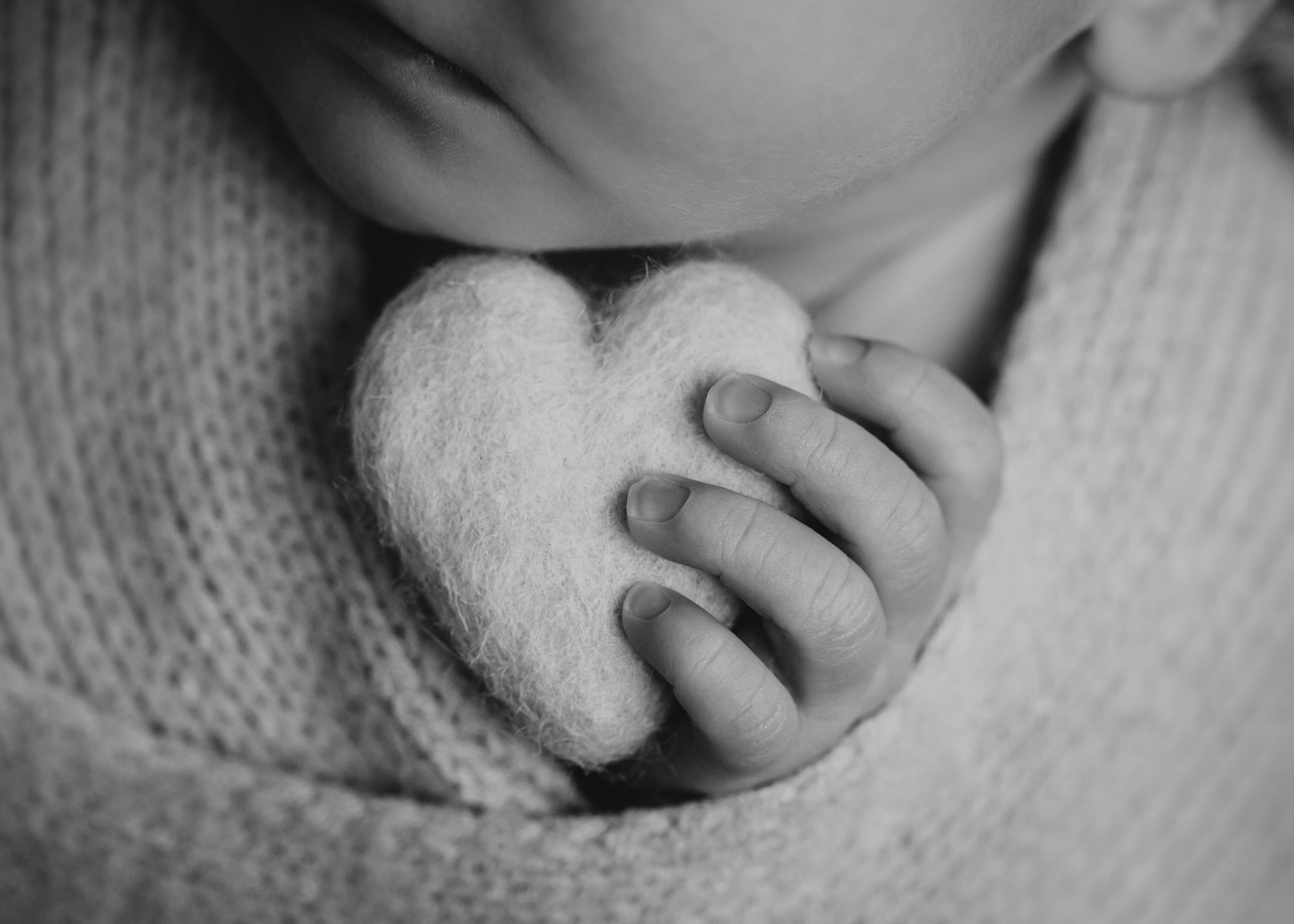 Dessau Babyfotoshooting, zarte Schwarz-Weiß Aufnahme vom Baby mit Herz