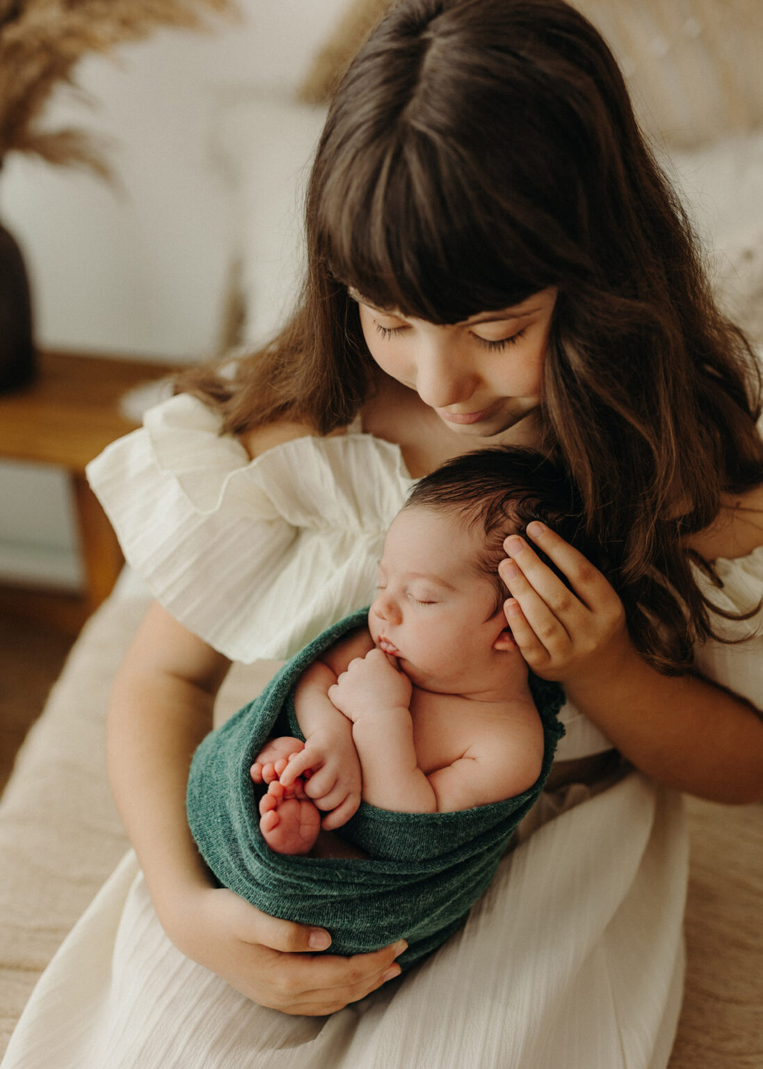 Wittenberg Babyfotoshooting, Schwester kuschelt mit neugeborenem Baby Bruder