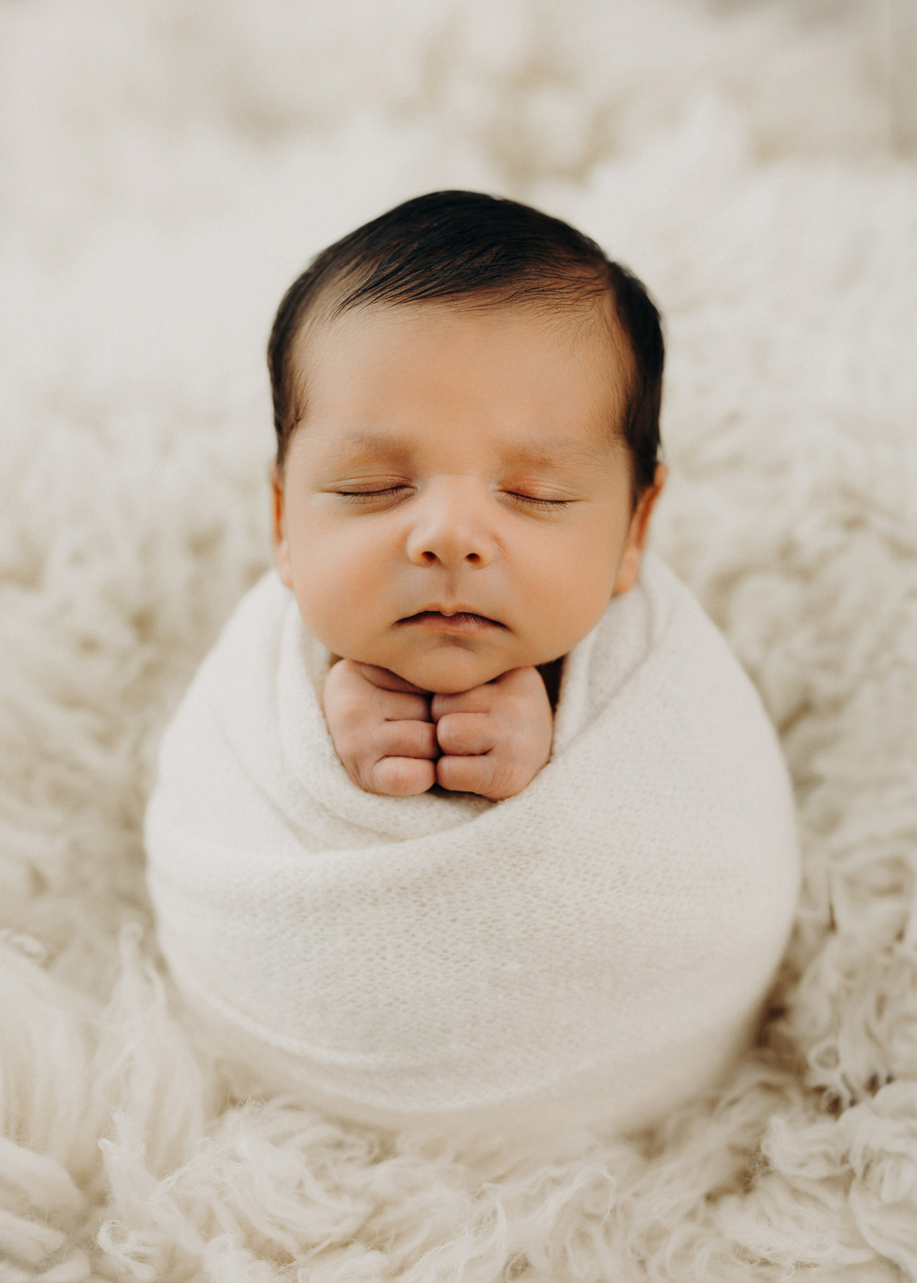 Studio Babyfotografie Leipzig, Neugeborenes Baby liebevoll eingepuckt für Fotoshooting