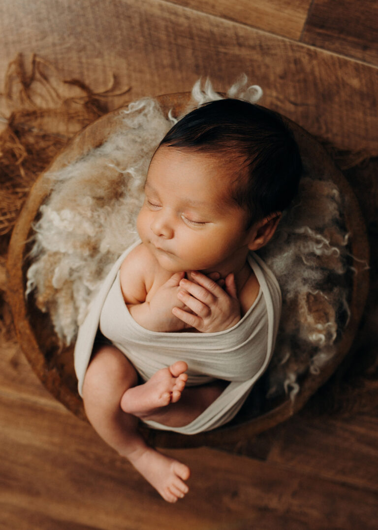 Baby liegt schlafend in Holzschale, kreative Babyfotografie in Leipzig, Wurzen, Eilenburg