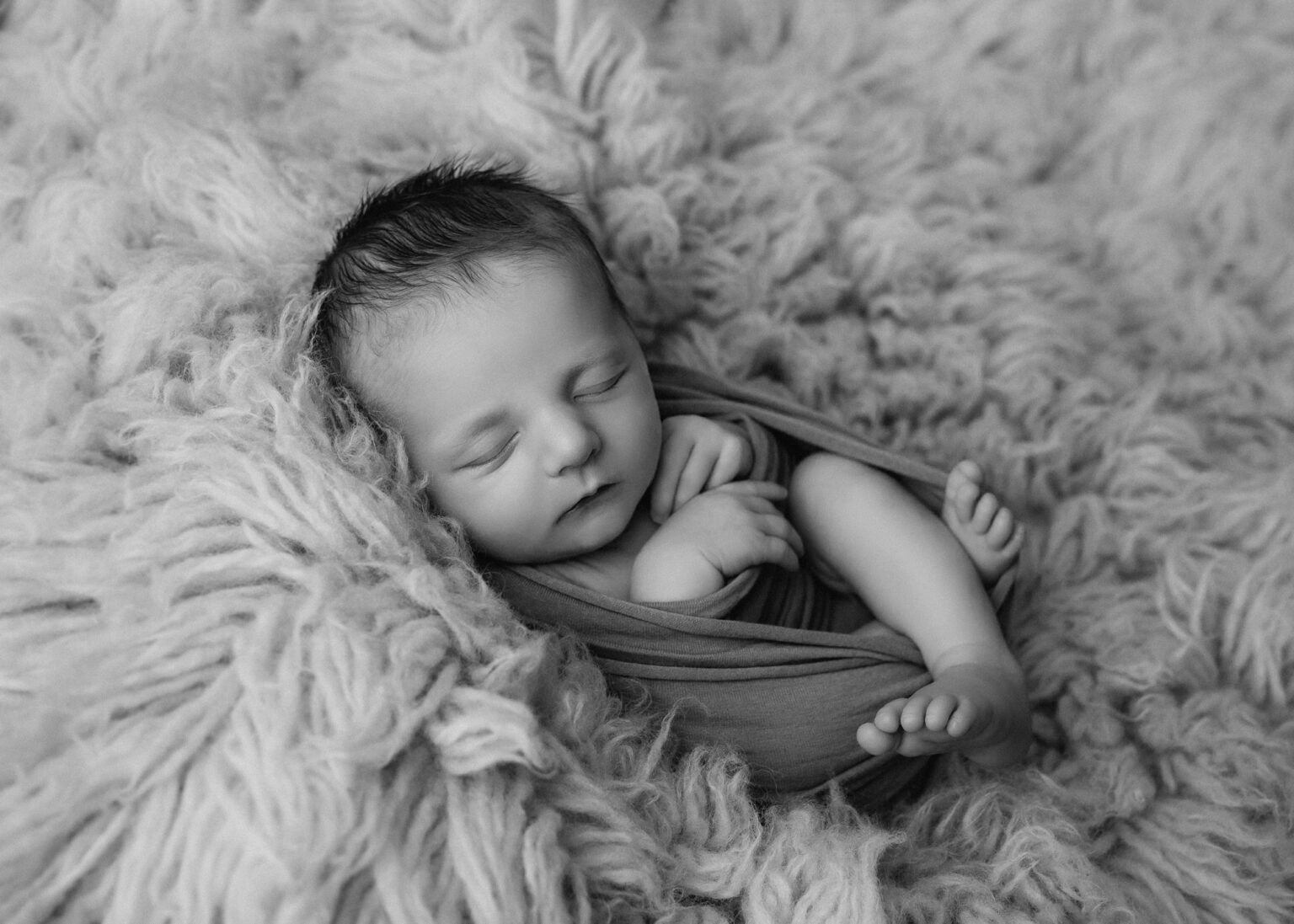 Baby liegt schlafend auf Fell bei Baby-Fotoshooting, Babyfotograf im Raum Leipzig, Wurzen, Eilenburg
