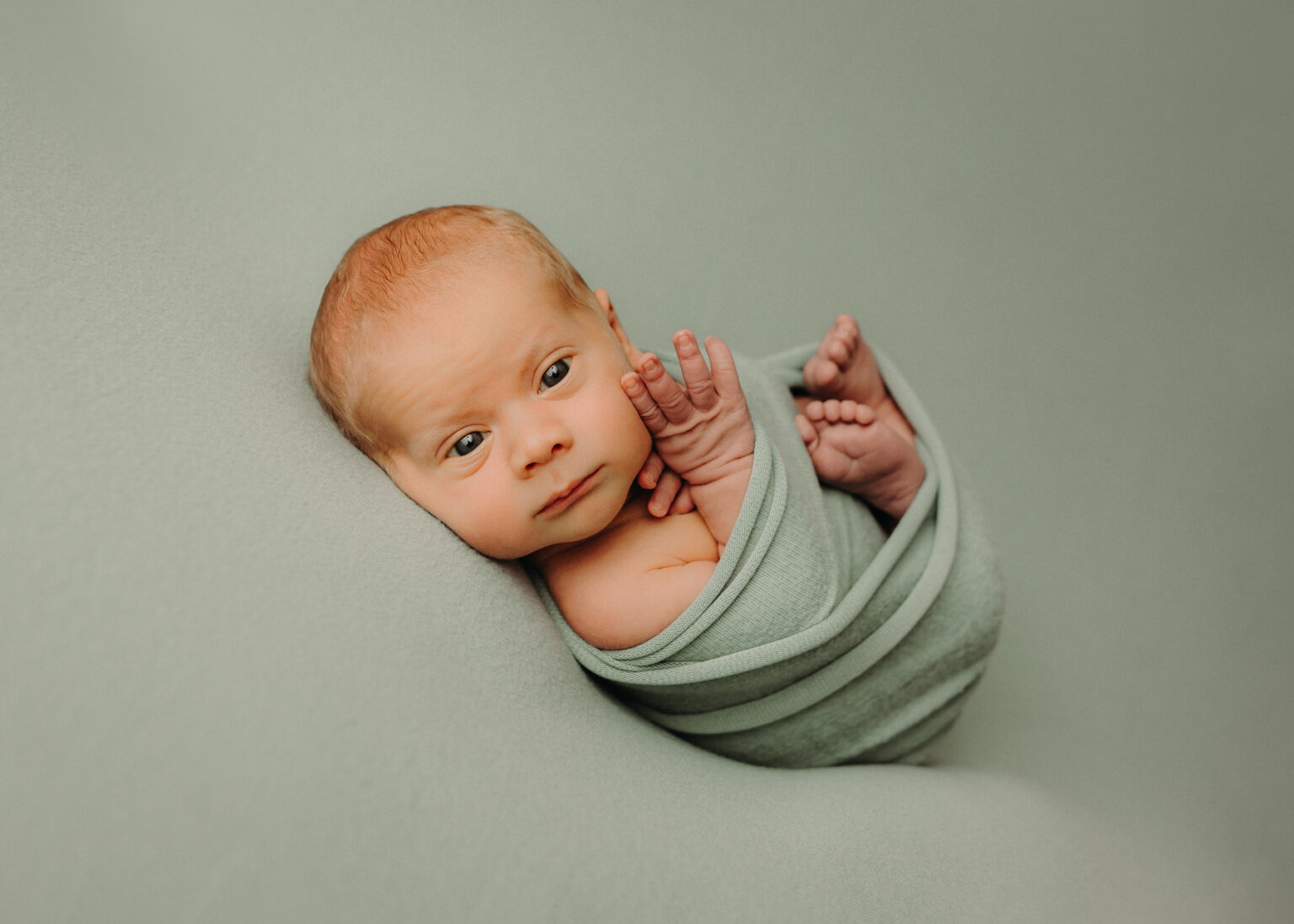 Studio Babyfotografie Leipzig, Neugeborenes Baby liebevoll eingewickelt