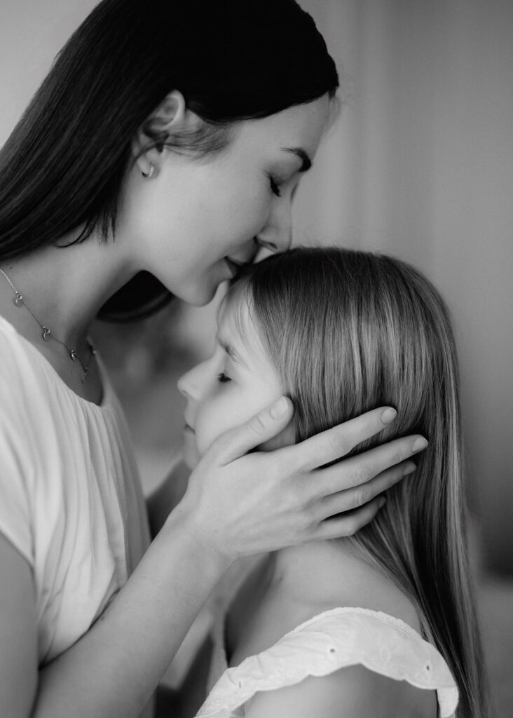 Liebevolles Foto mit Mutter und Tochter in heller, natürlicher Studioatmosphäre