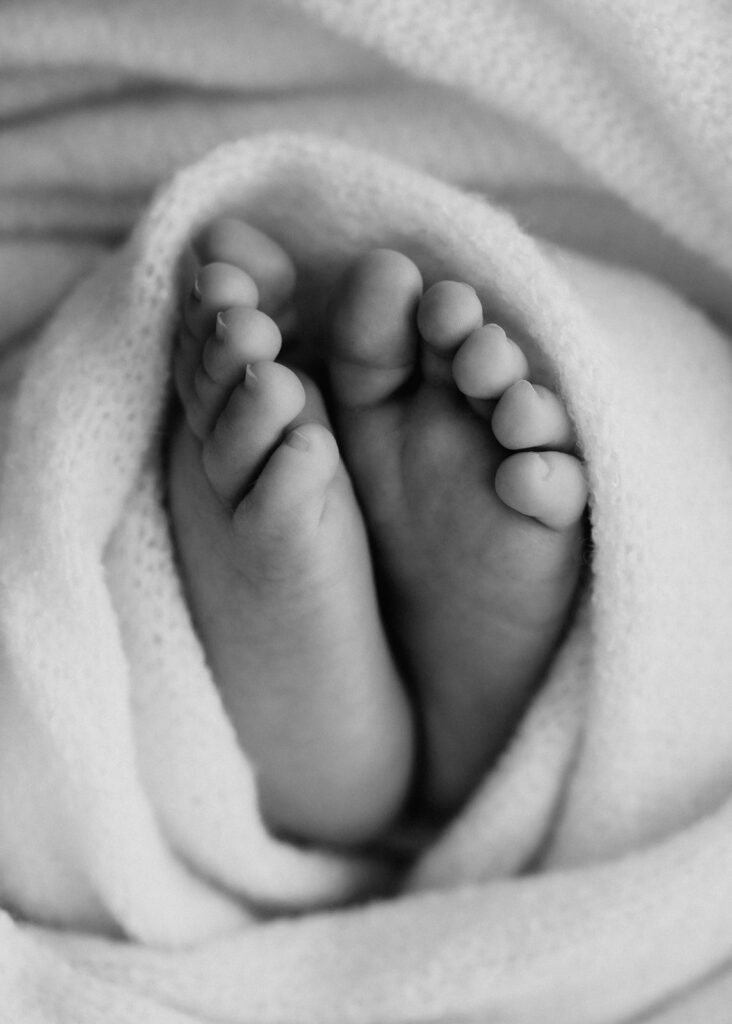 Schwarz-Weiß-Foto Detailaufnahme Babyfüße. Babyfotoshooting neugeborenes Baby